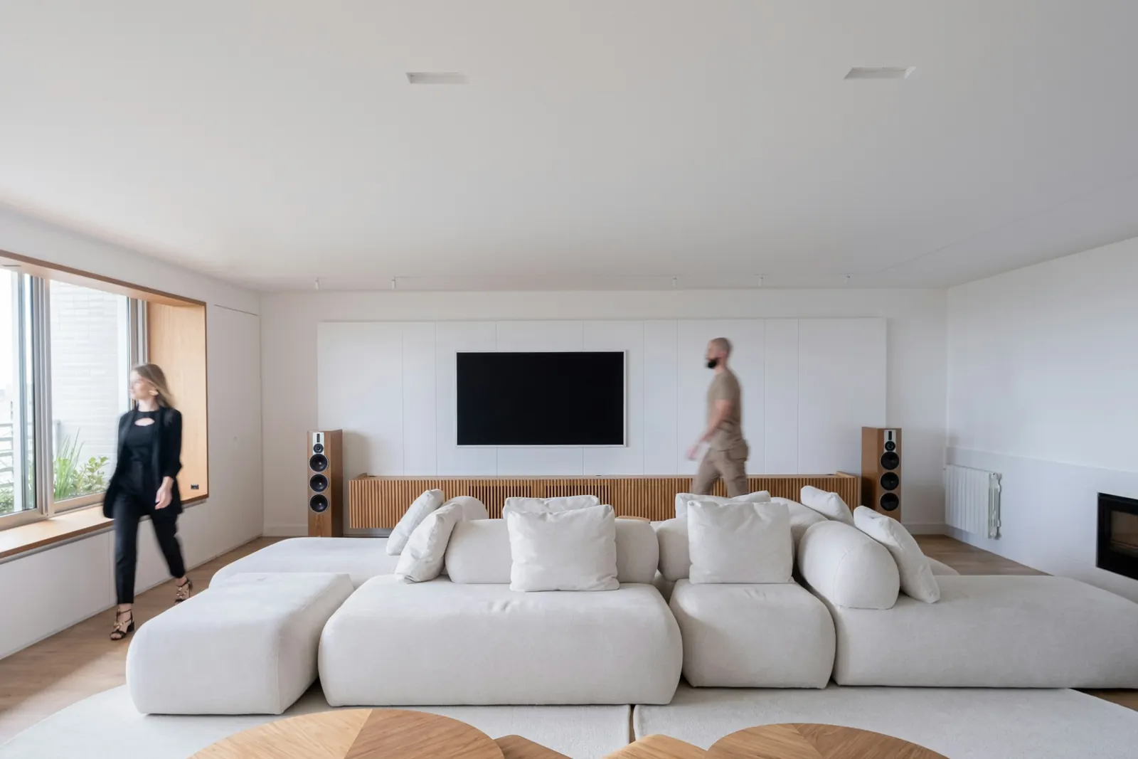 A wide low sofa in front of a white storage wall