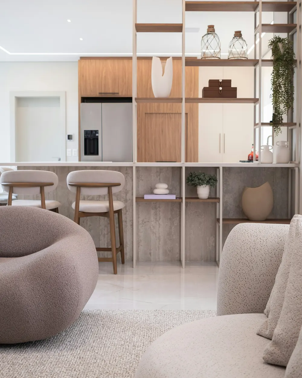 Open shelving between the living room and the kitchen, with timber bar stools