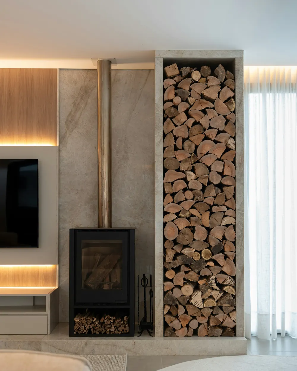 The wood stove and stone-clad log store in the family room