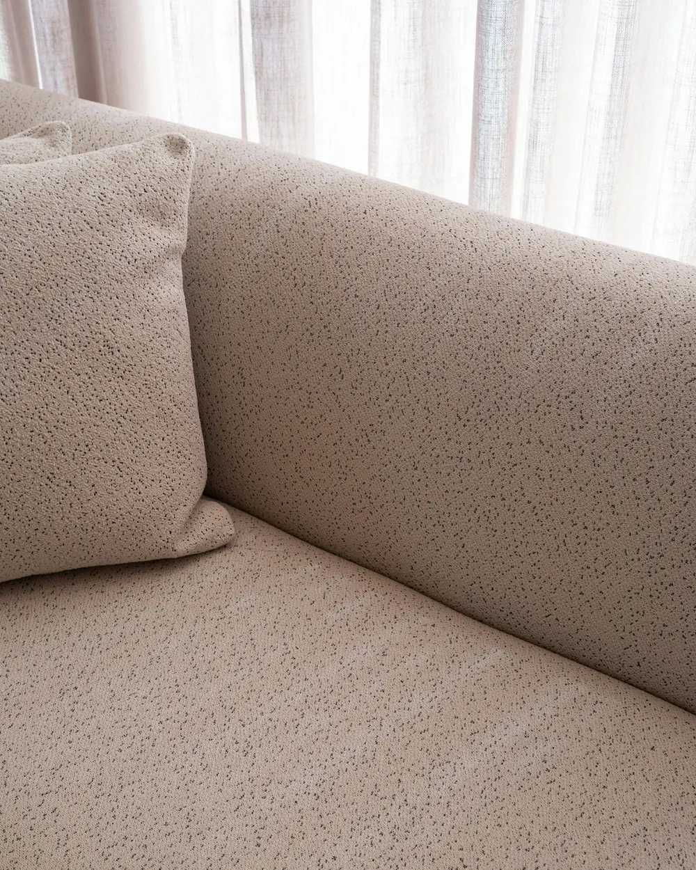 Close-up of the bouclé sofa fabric against the linen sheers