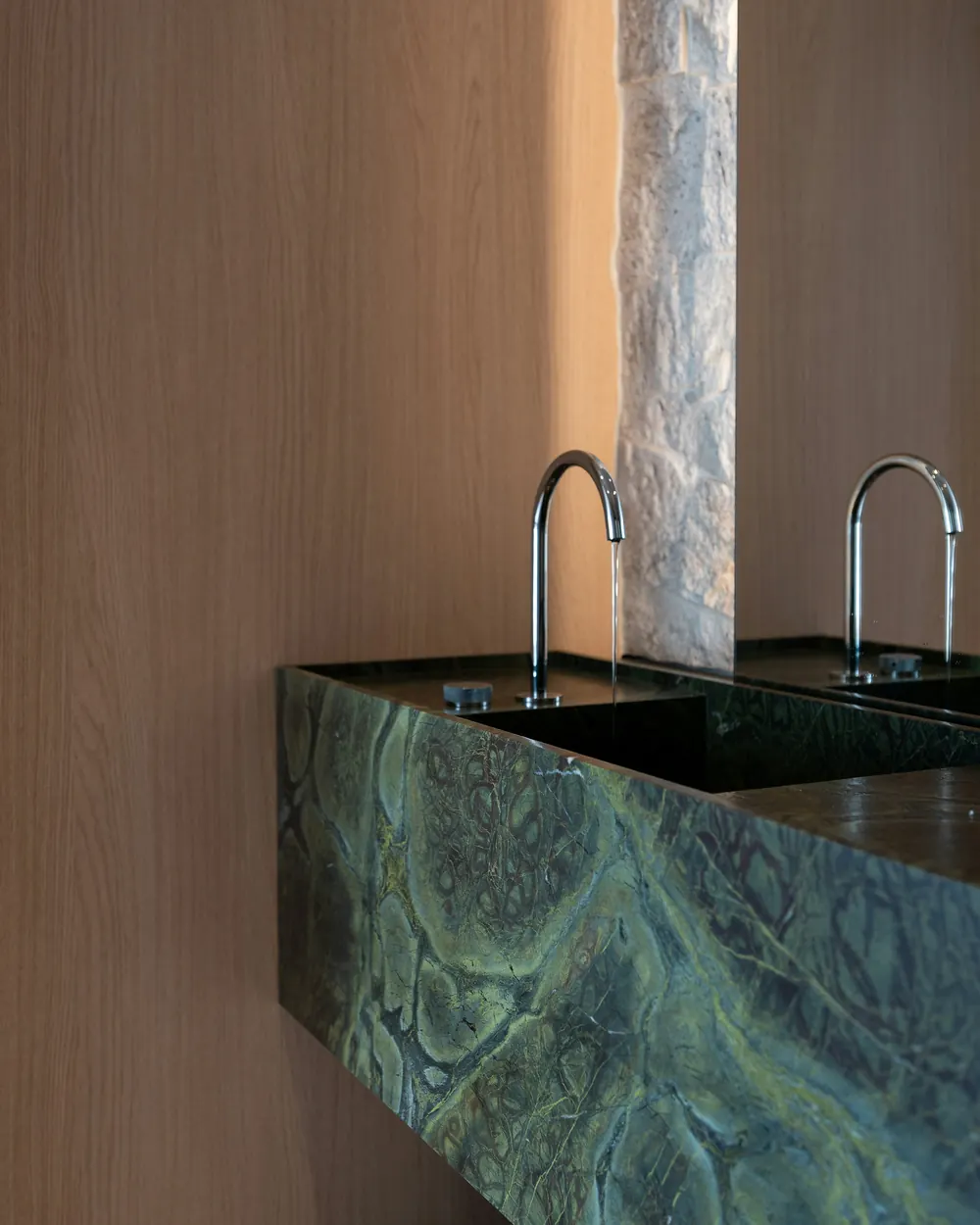 A green marble vanity between oak and stone